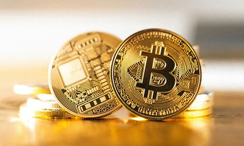 Kryptowährung visualisiert als goldene Bitcoinmünzen